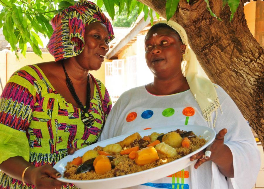 Dos mujeres con un plato de comida en un taller de cocina de Gambia