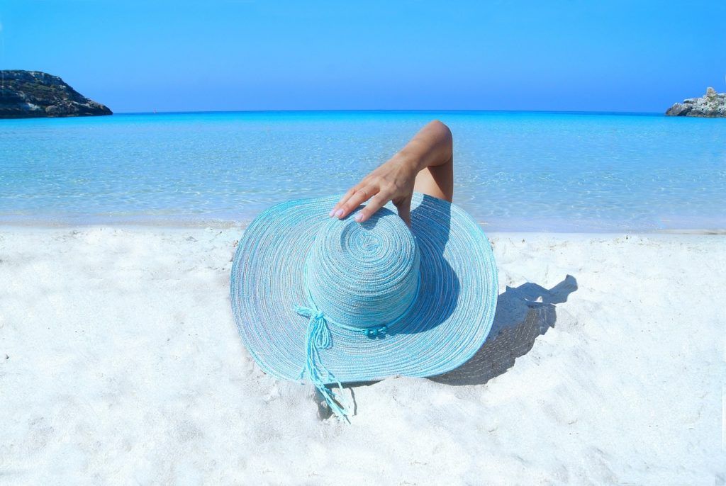 Mujer con sombrero tumbada en la playa