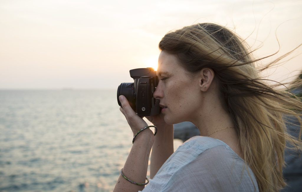 mujer hace fotografia junto al mar