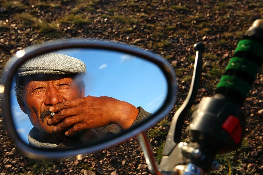 Hombre reflejado en un retrovisor en Mongolia
