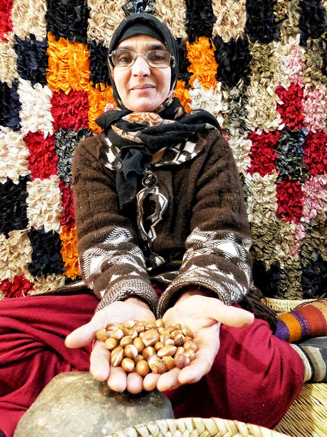 Trabajadora de una cooperativa de argán muestra un puñado de semillas.