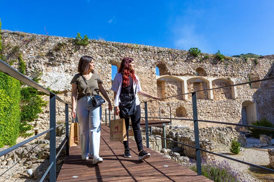 dos mujeres pasean entre las ruinas del castillo de doña mencía