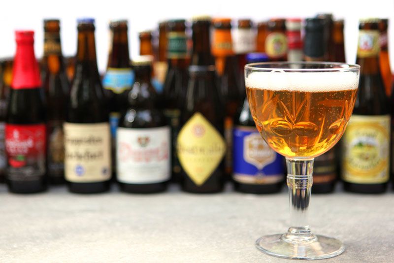 cervezas belgas en botella y una copa
