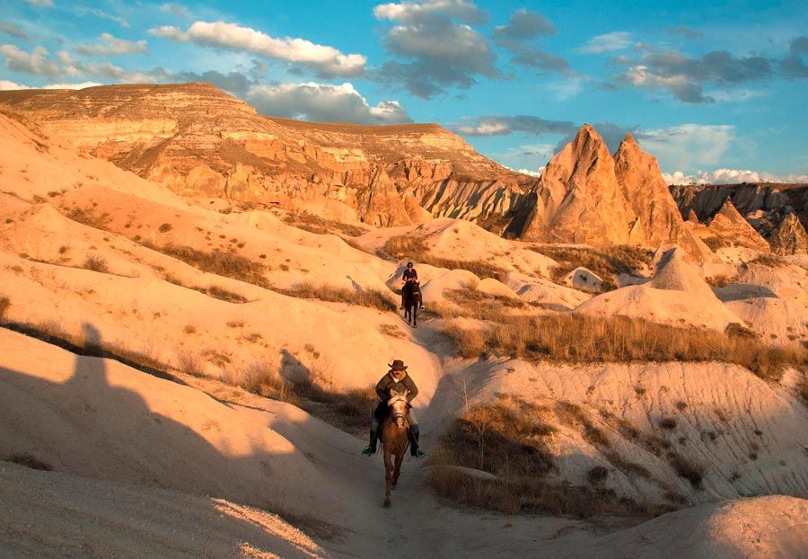 Dos jinetes pasean a caballo en Goreme, una excursión a Capadocia
