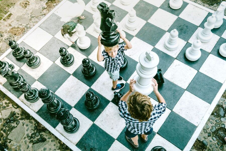 Niños jugando con un ajedrez gigante