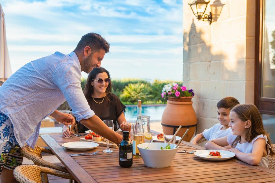 Familia sentada a la mesa dispuesta a comer en Malta
