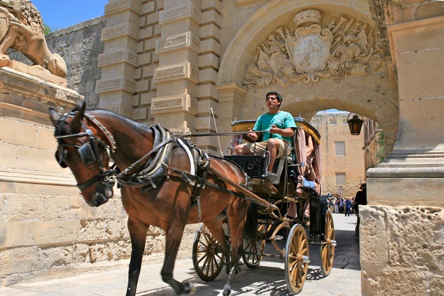 Un coche de caballo sale de la ciudad de Mdina en la isla de Malta