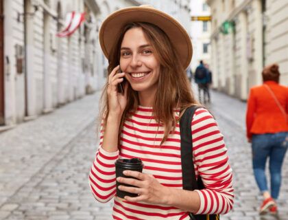 mujer de viaje sonriendo con un móvil