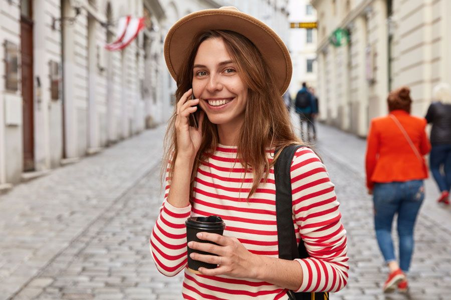 mujer de viaje sonriendo con un móvil