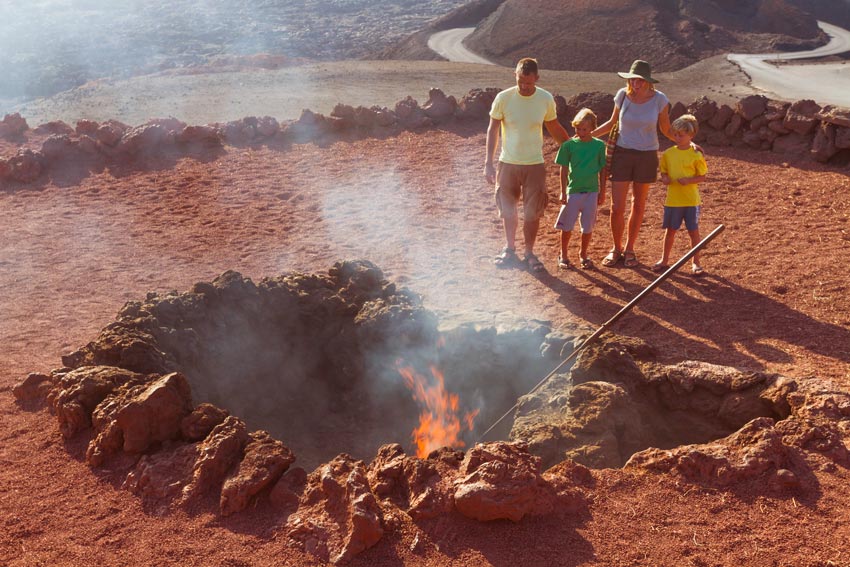 Una familia observa el fuego de un cráter en el Parque Nacional de Timanfaya.