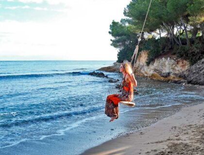 mujer columpiándose en la playa S'Estañol en Ibiza