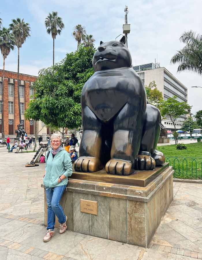 Sania en el centro de Medellín frente a una escultura de un gato