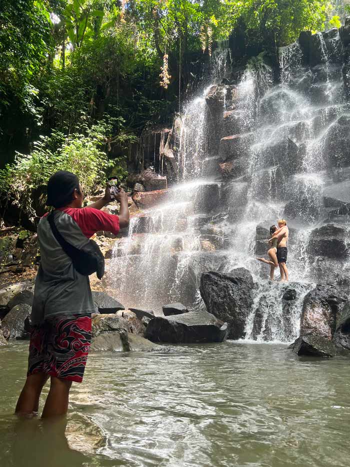 pareja haciéndose fotos en la cascada de Kanto Lampo en Bali