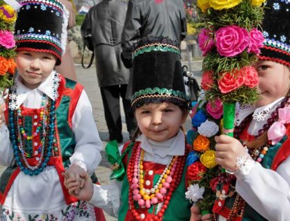 Niñas con las palmas polacas y trajes tradicionales de Polonia.
