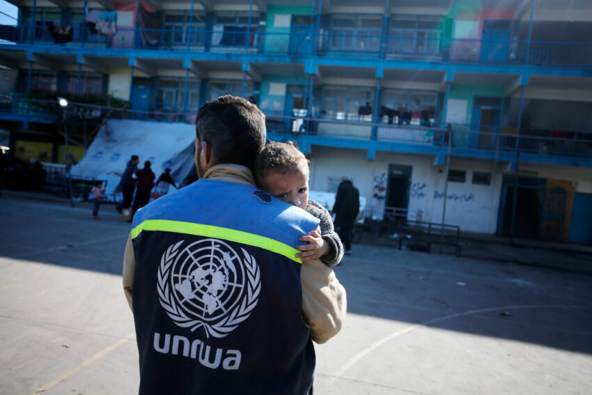 Un trabajador humanitario de UNRWA carga a un niño herido en el patio de una escuela convertida en refugio en el centro de Gaza, uno de los hasta 150 refugios de emergencia gestionados por UNRWA, enero de 2024. 